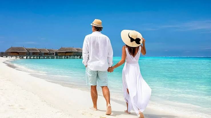 Couple holding hands on a sunset beach